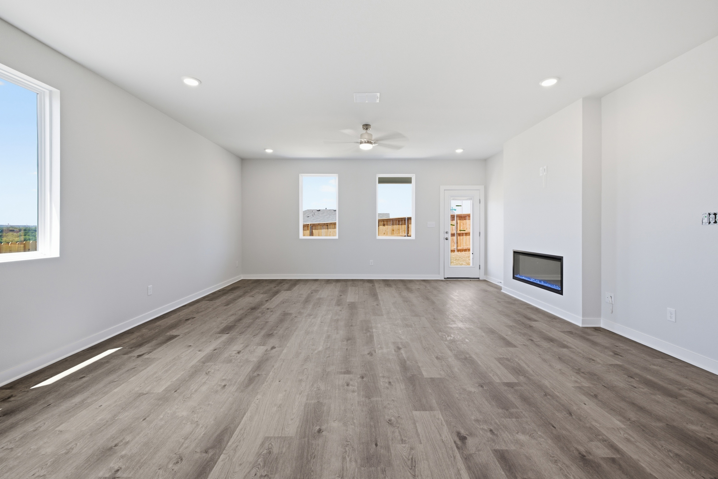 A room with a wood floor and a wood floor with a television on it.