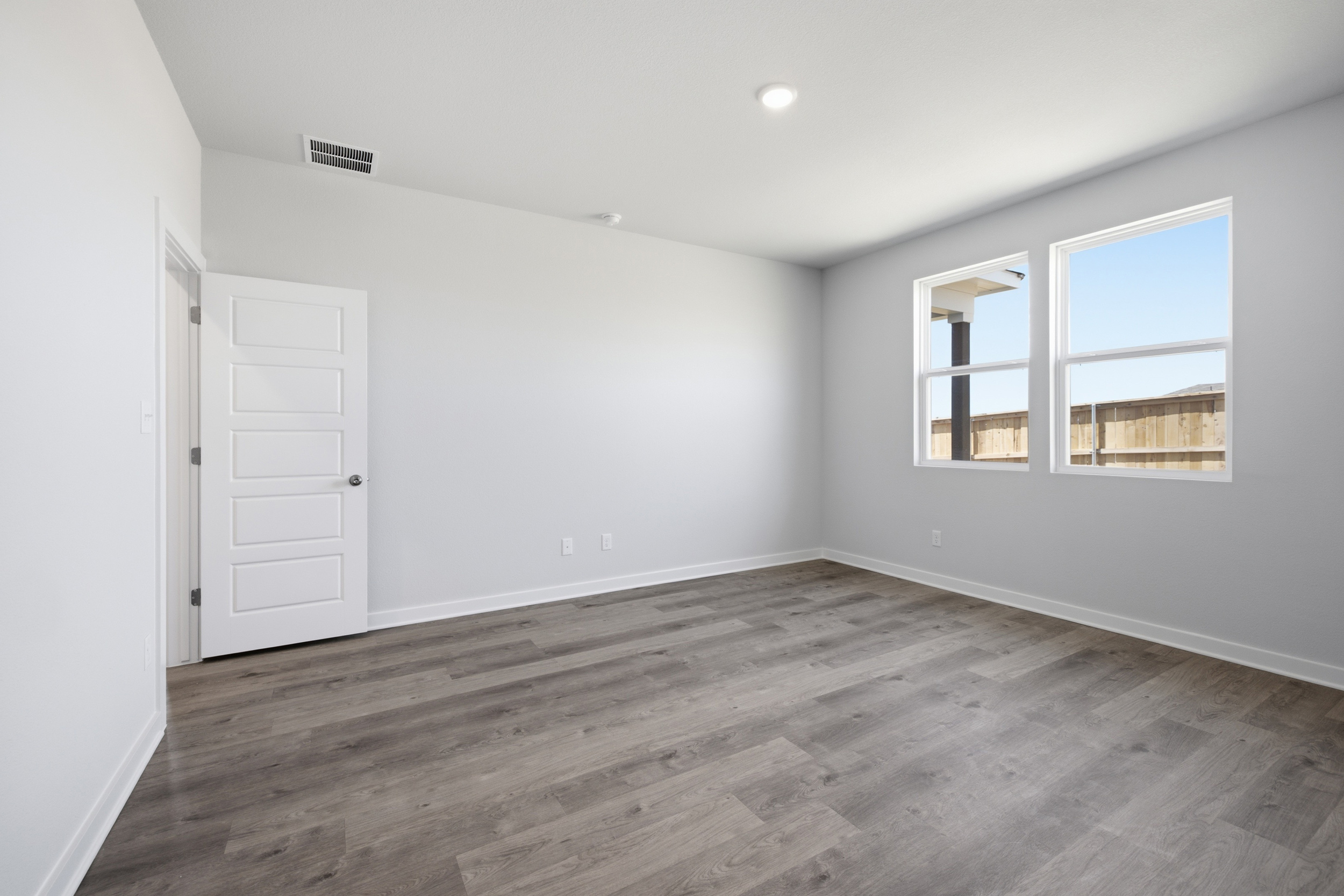 A room with white walls and a wood floor.