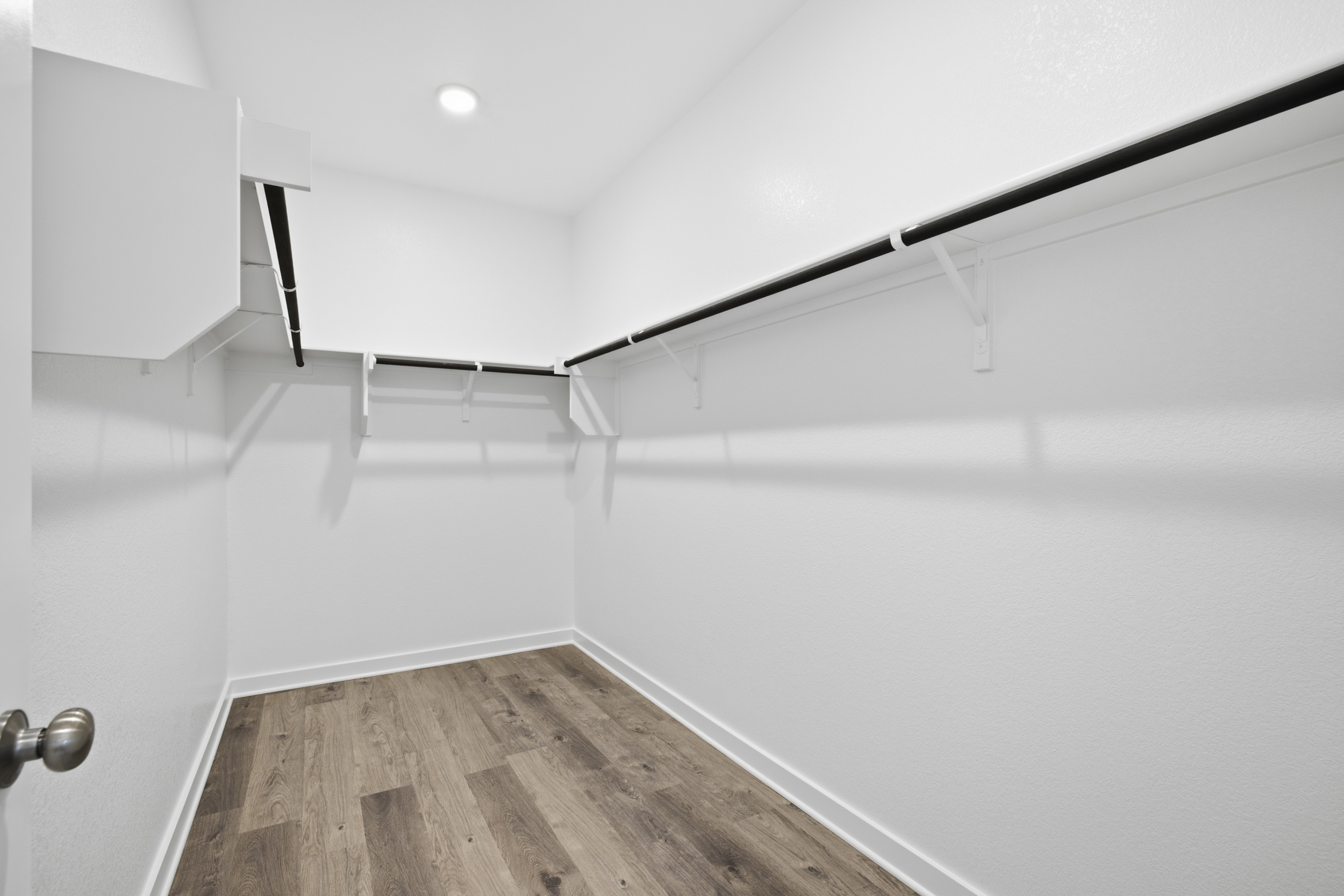 A white room with a wood floor.