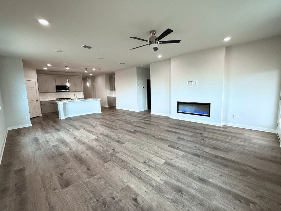 A large empty room with a wood floor and a wood floor.