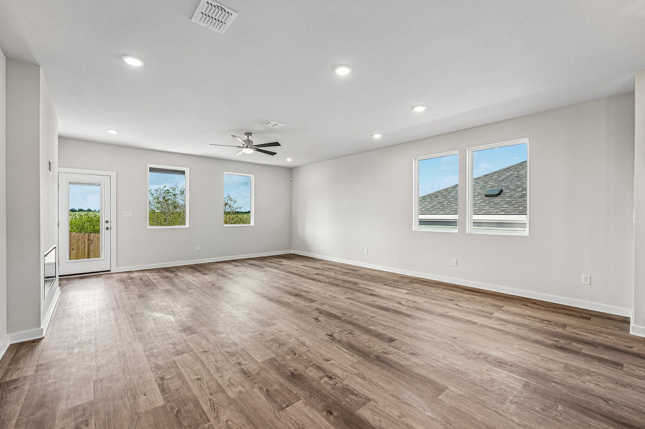 A room with a wood floor and a wood floor with a ceiling fan.