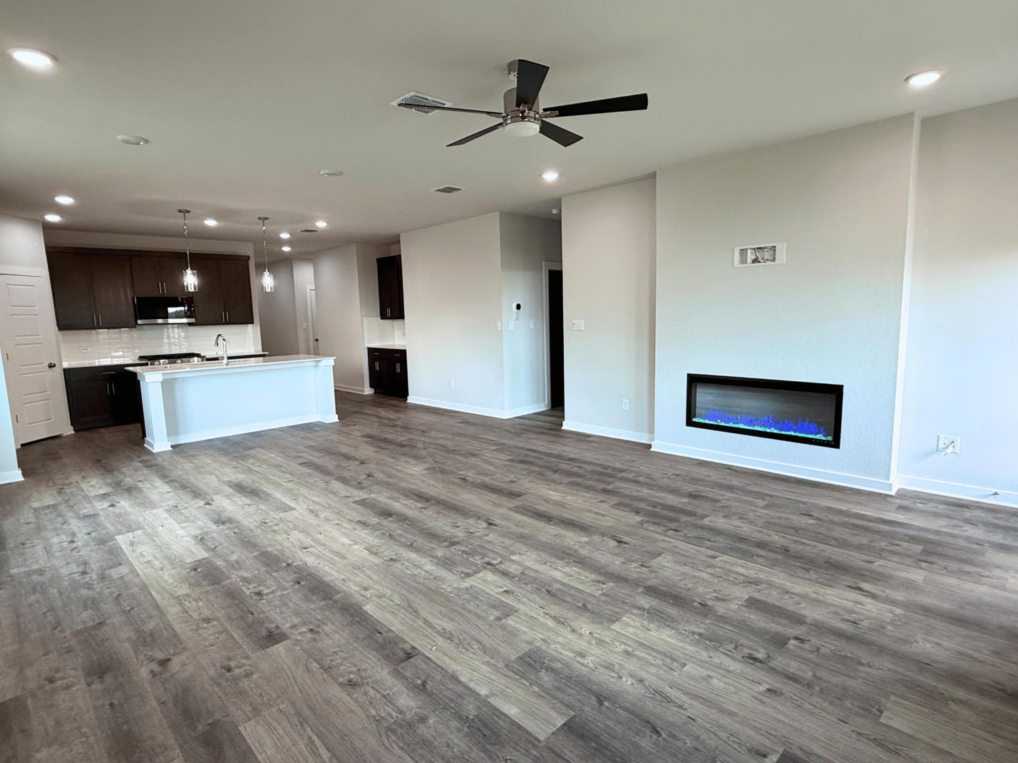A large empty room with a large television and a wood floor.