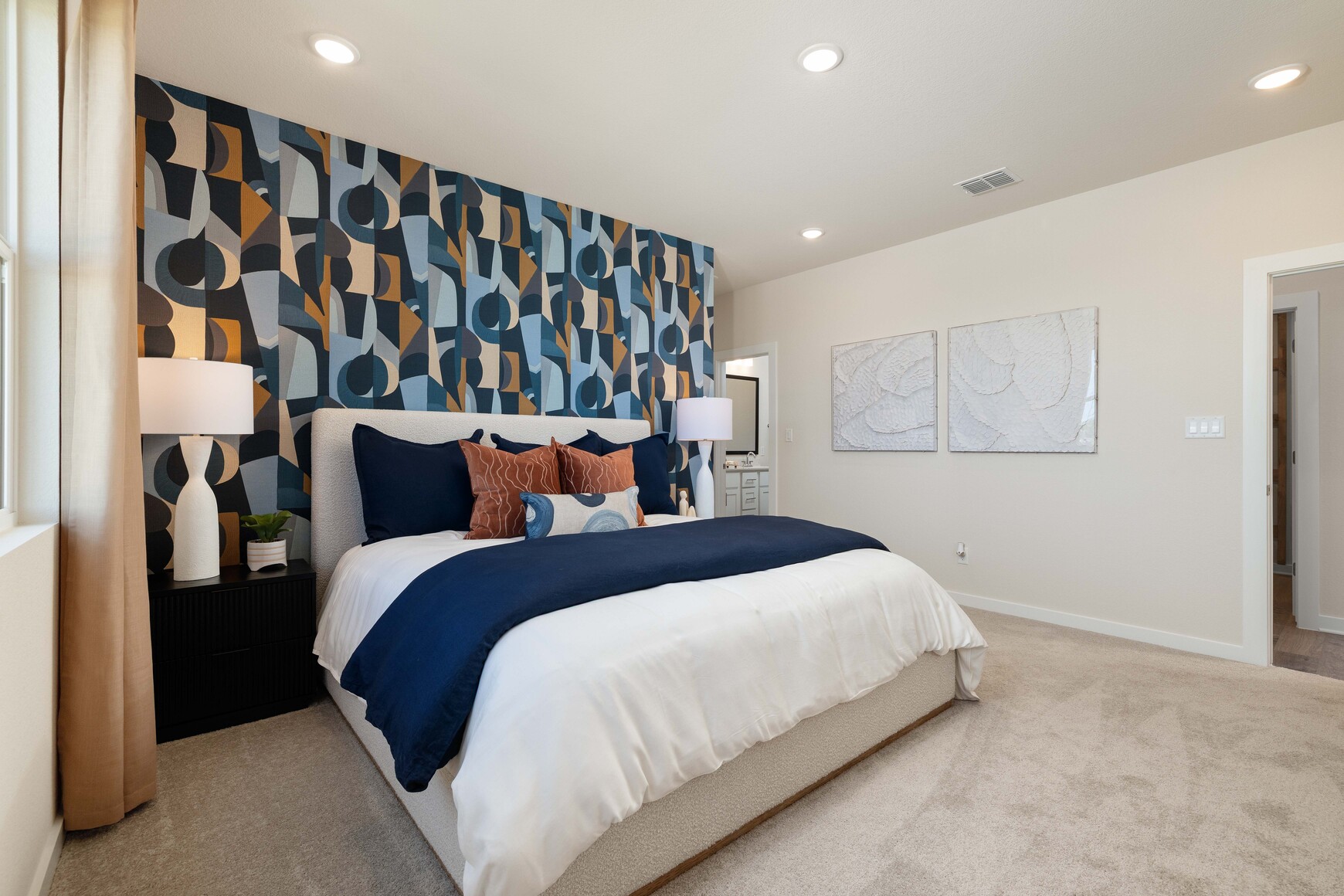 A bedroom with a bed and lamps.