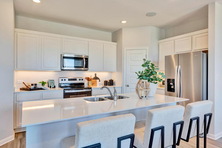 A kitchen with white cabinets.