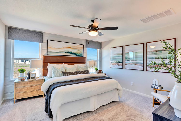 A bedroom with a large bed and a fan.
