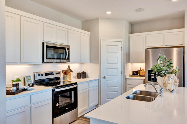 A kitchen with white cabinets.