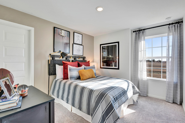 A bedroom with a bed and a desk.