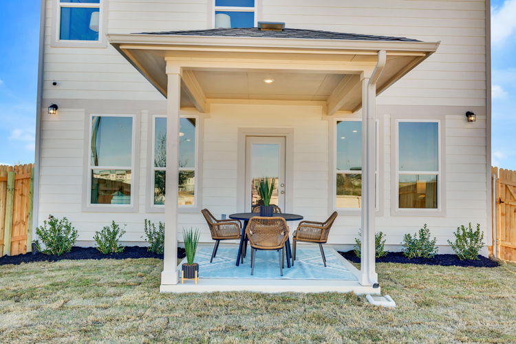A house with a patio and a table and chairs.