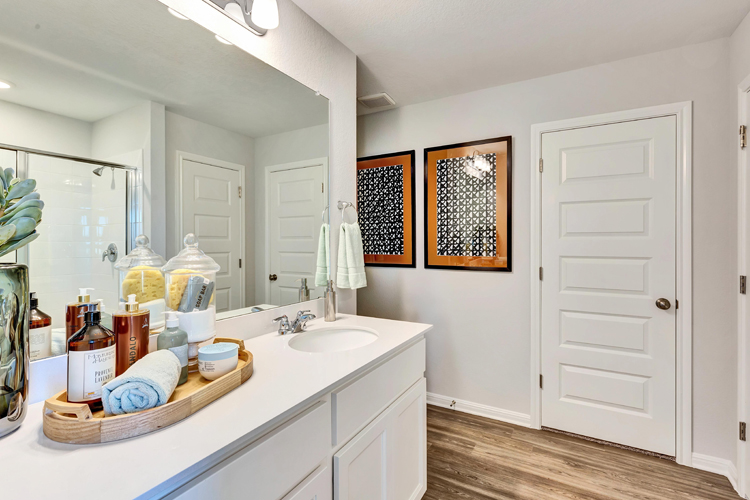 A bathroom with white cabinets.