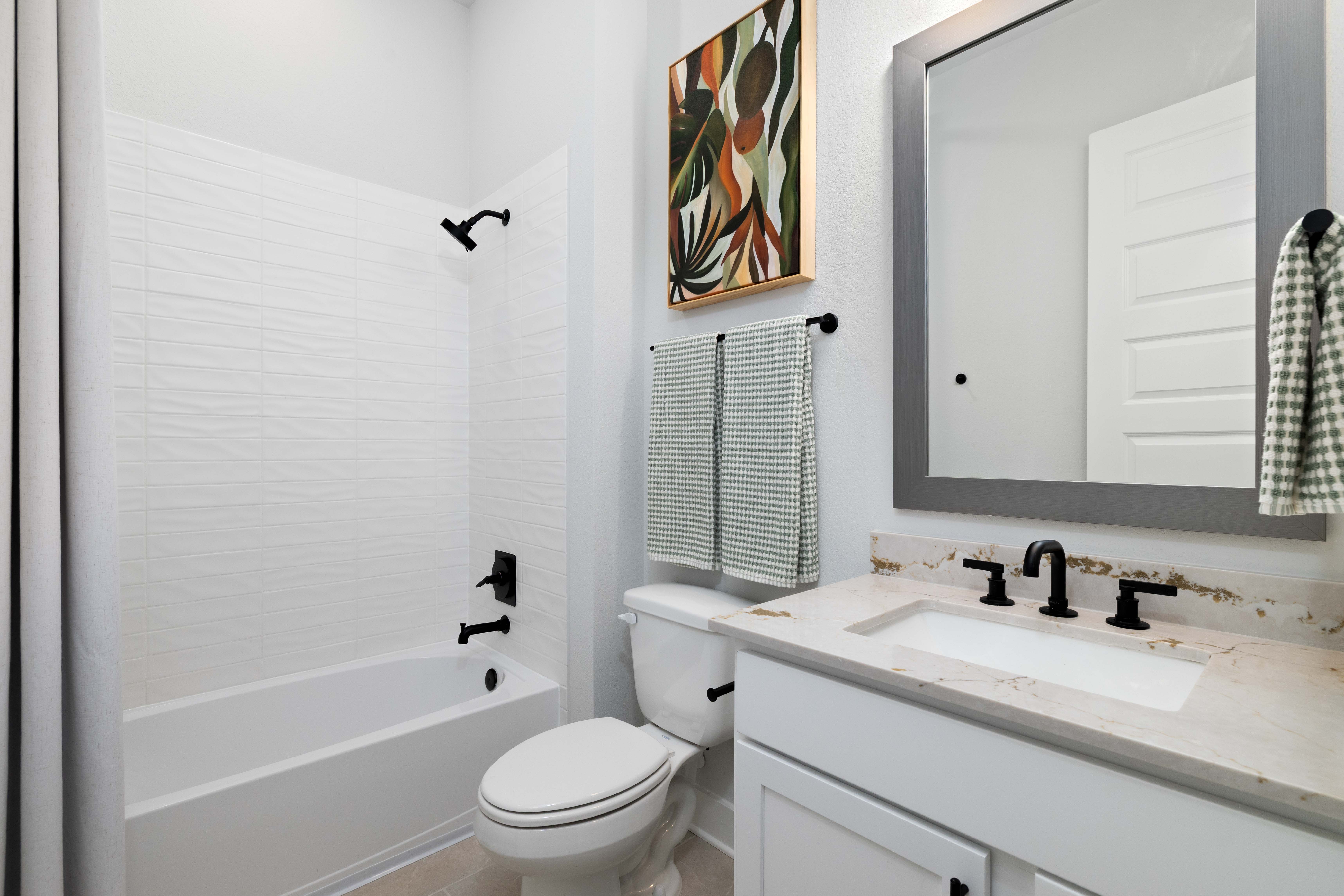A bathroom with a toilet sink and a bathtub.