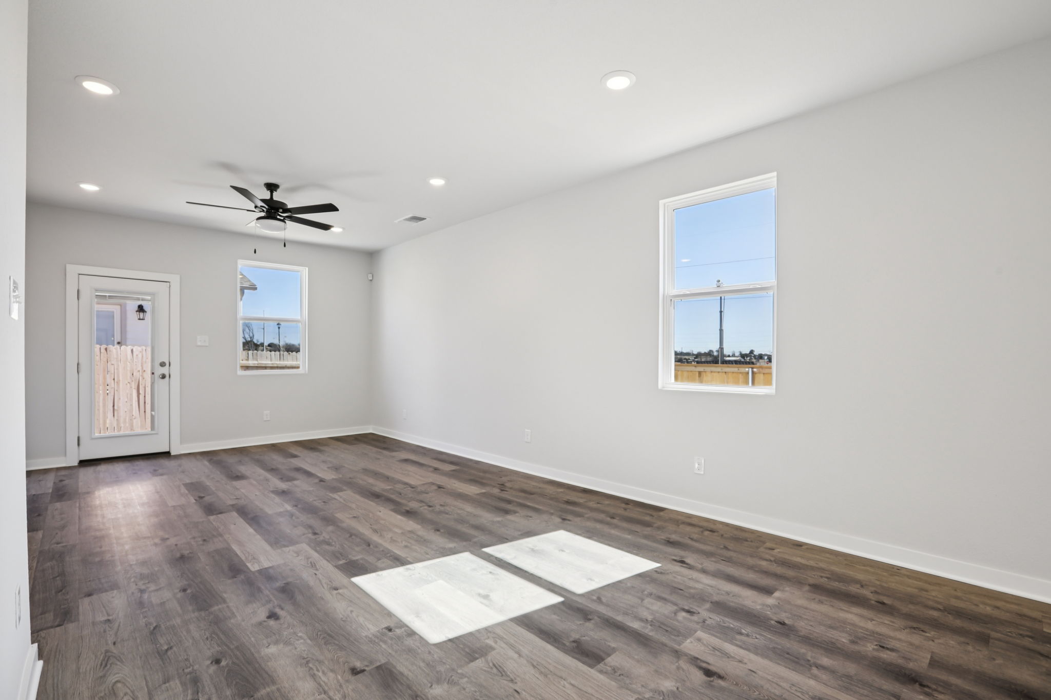 A room with a wood floor and a ceiling fan.