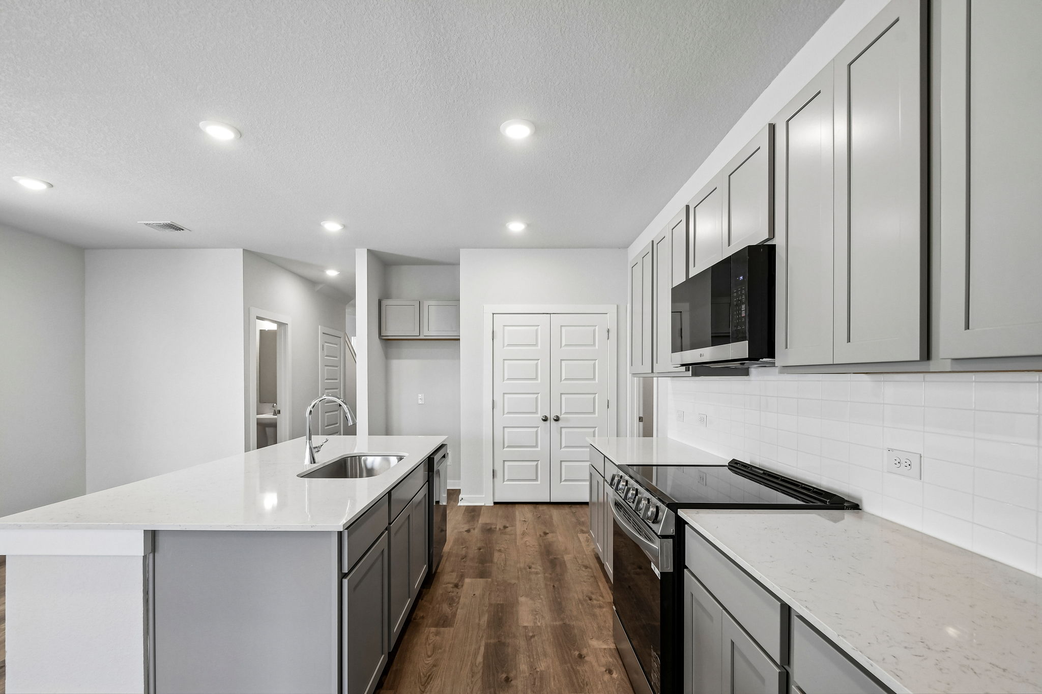A kitchen with white cabinets.