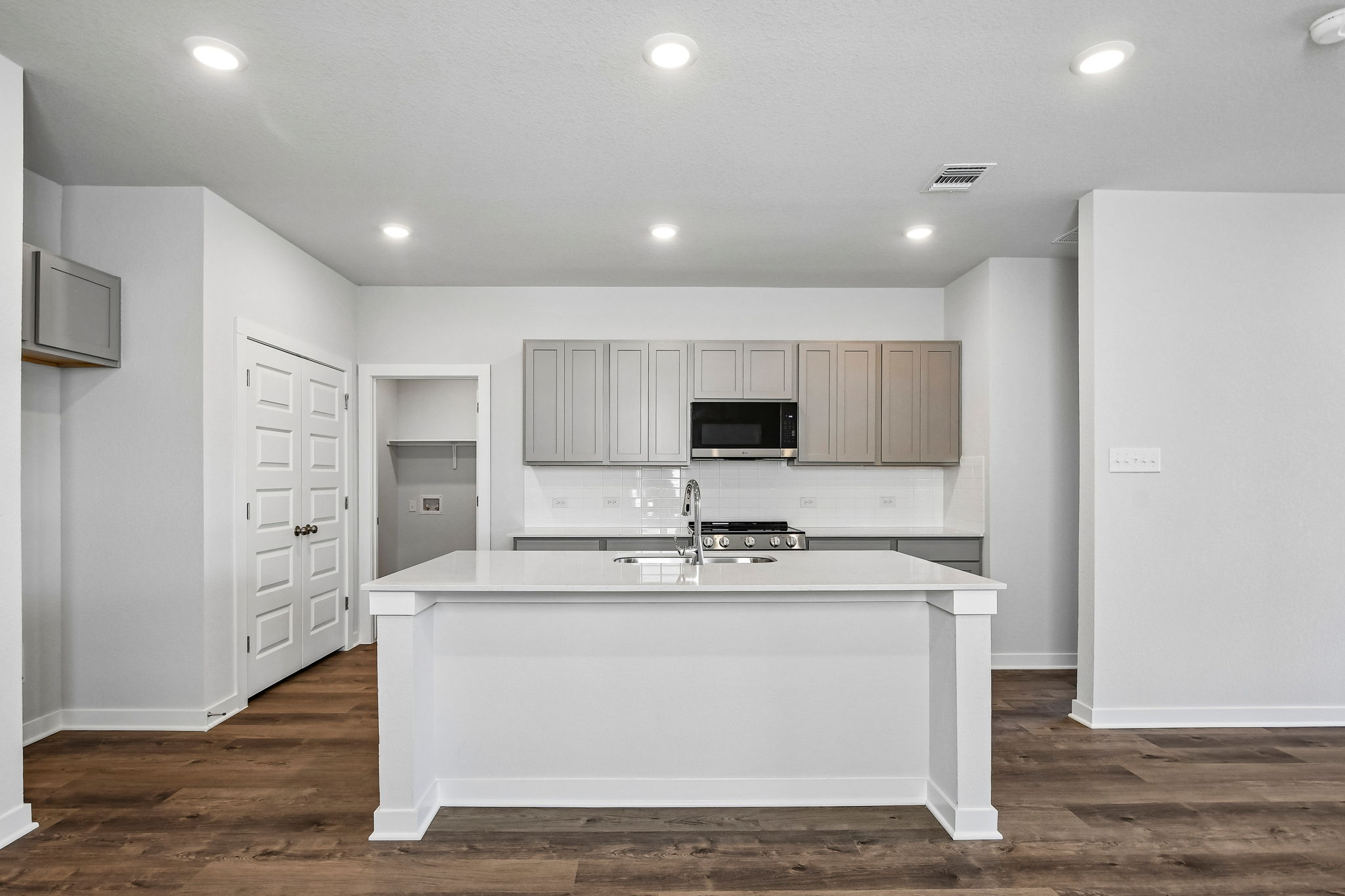 A kitchen with white cabinets.