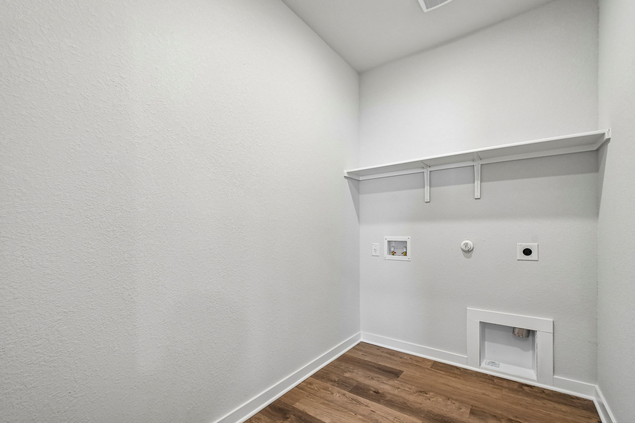 A white room with a wood floor.