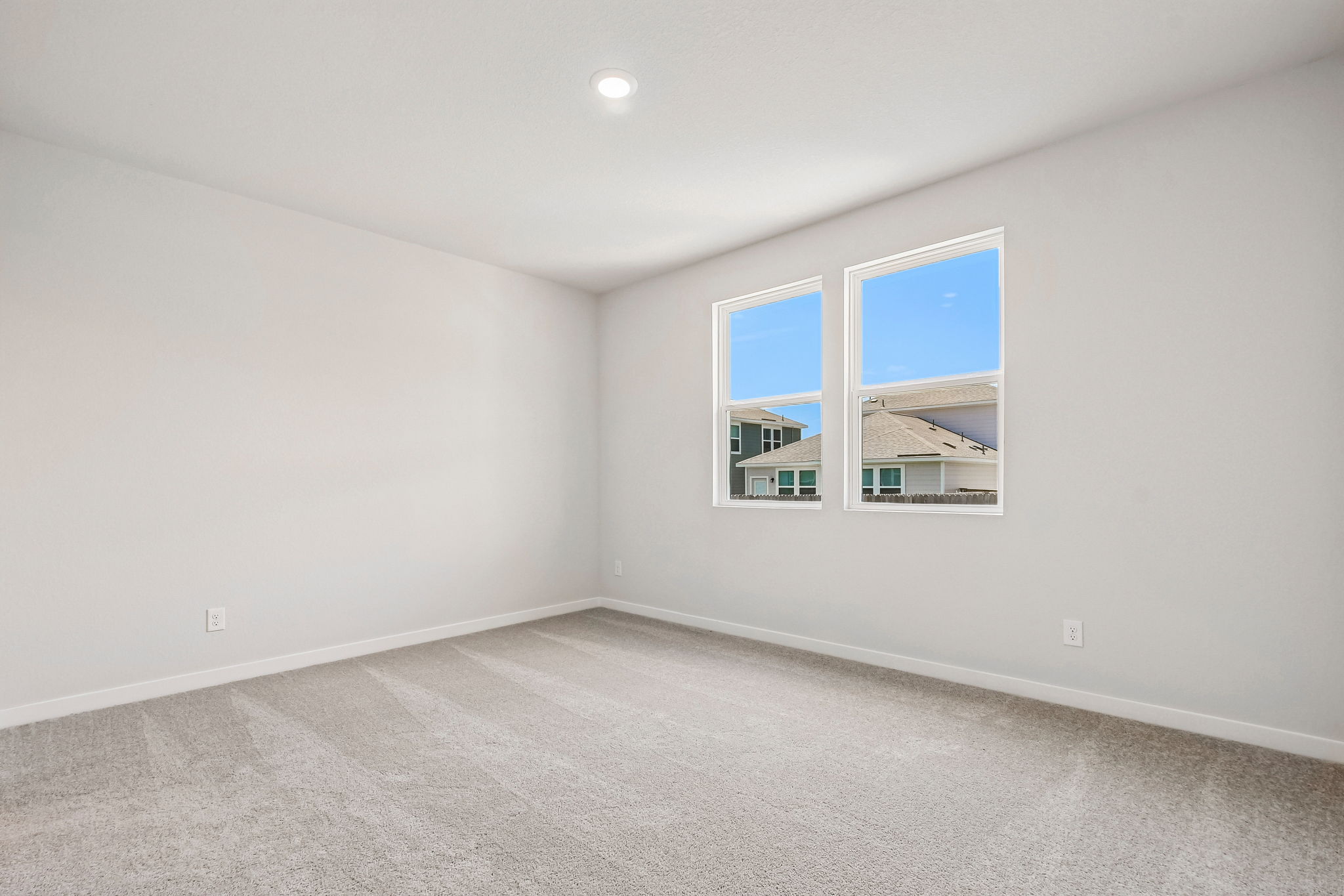 A room with a window and a white wall.