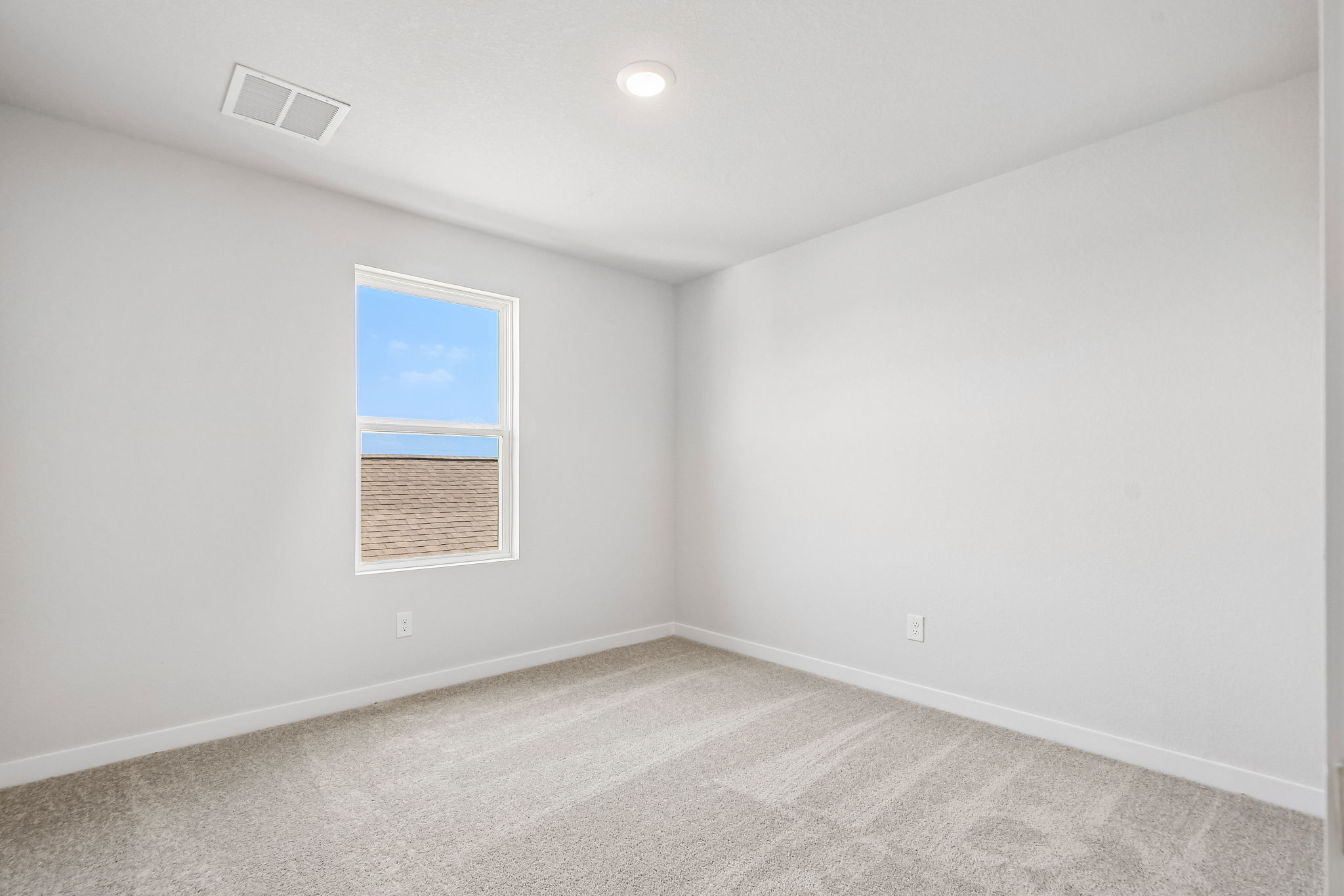 A room with a window and a carpet.