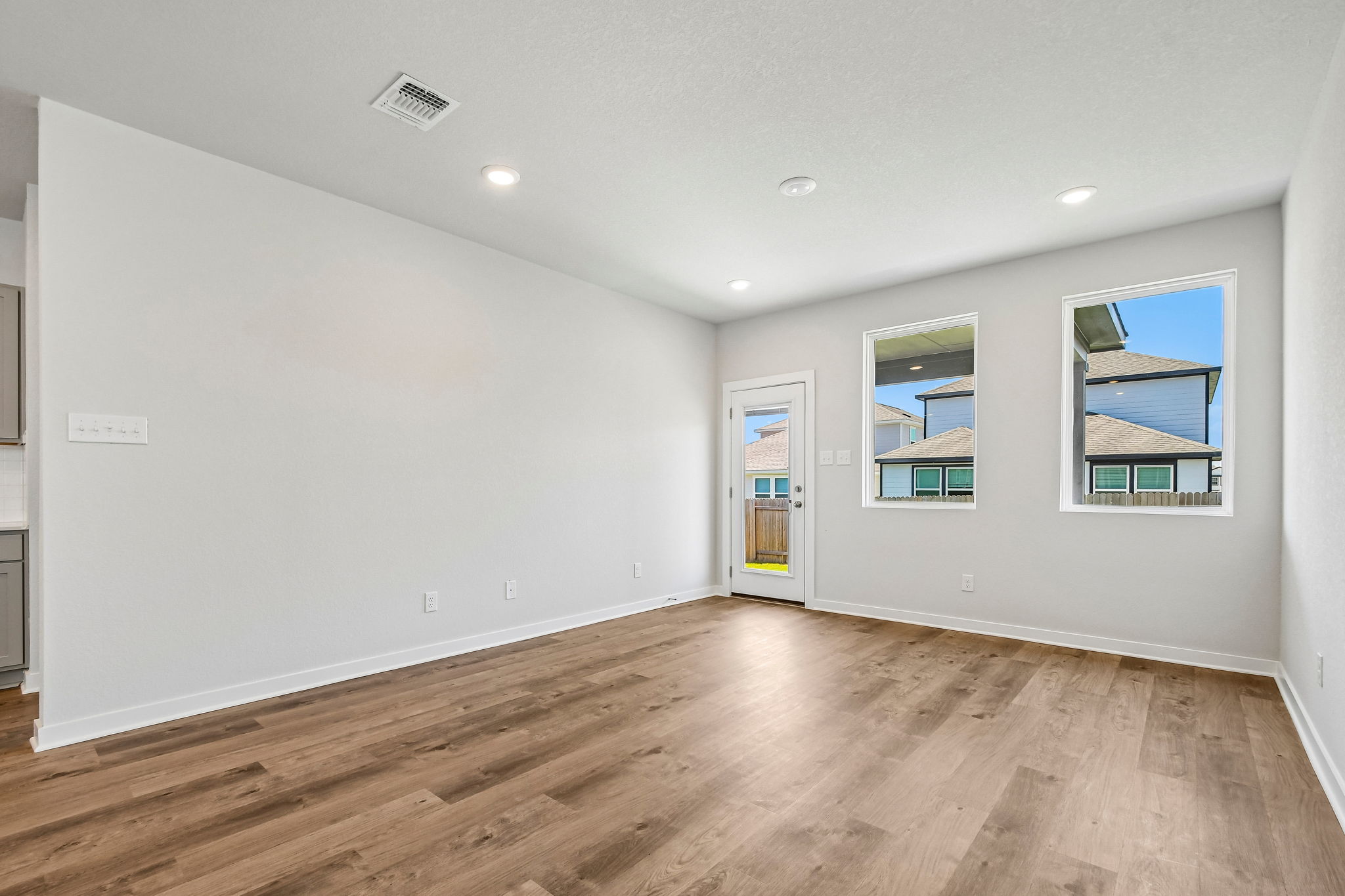A room with a wood floor and a wood floor with a door.