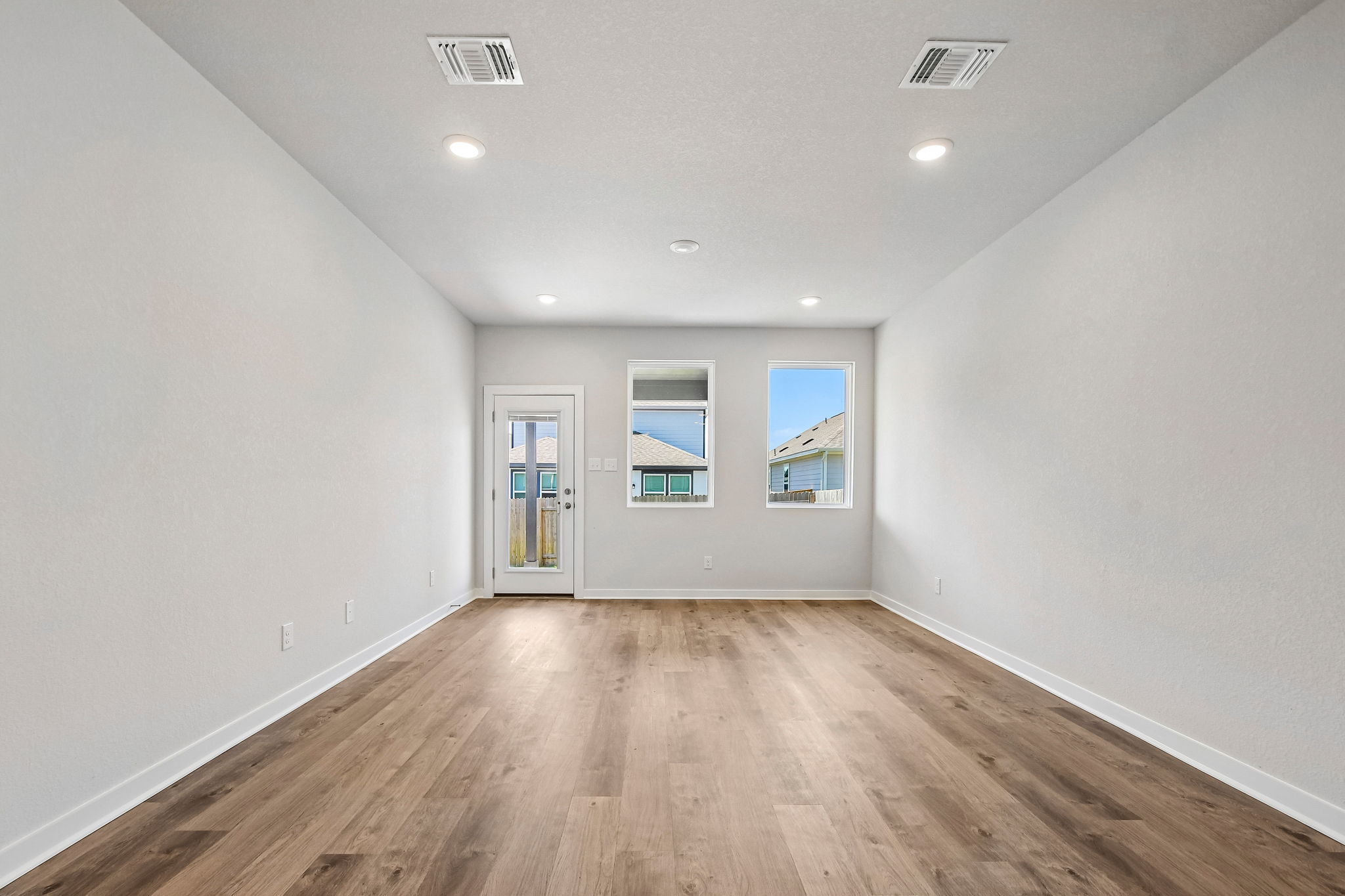 A room with white walls and a wood floor.