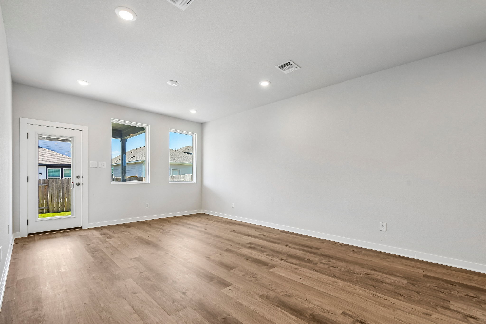 A room with a wood floor and white walls.