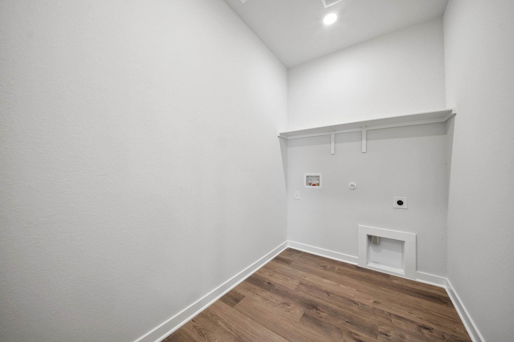 A white room with a wood floor.