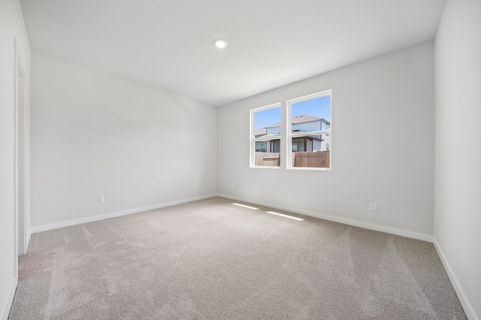 A room with a window and a carpet.