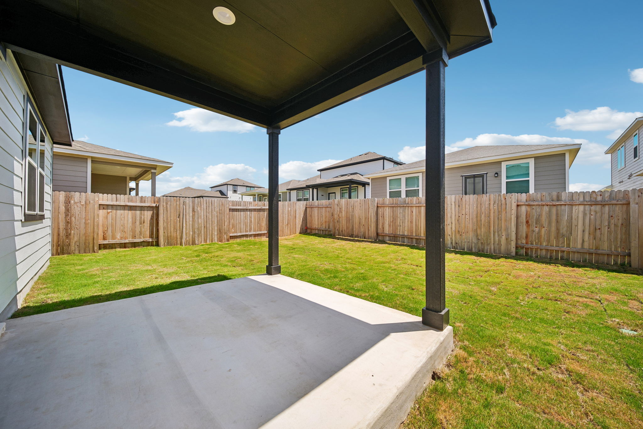 A backyard with a fence and a wood fence.