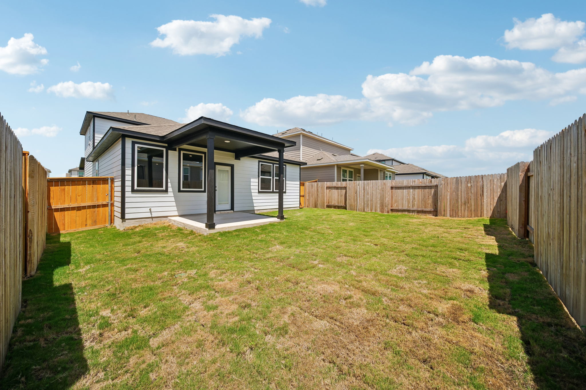 A fenced in yard with a house and a fence.