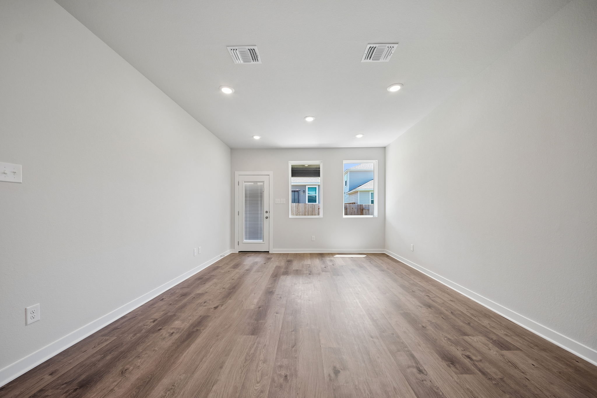 A room with a wood floor and white walls.