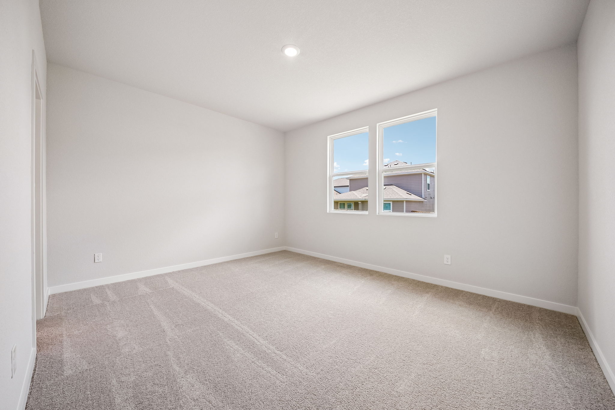 A room with a window and a carpet.