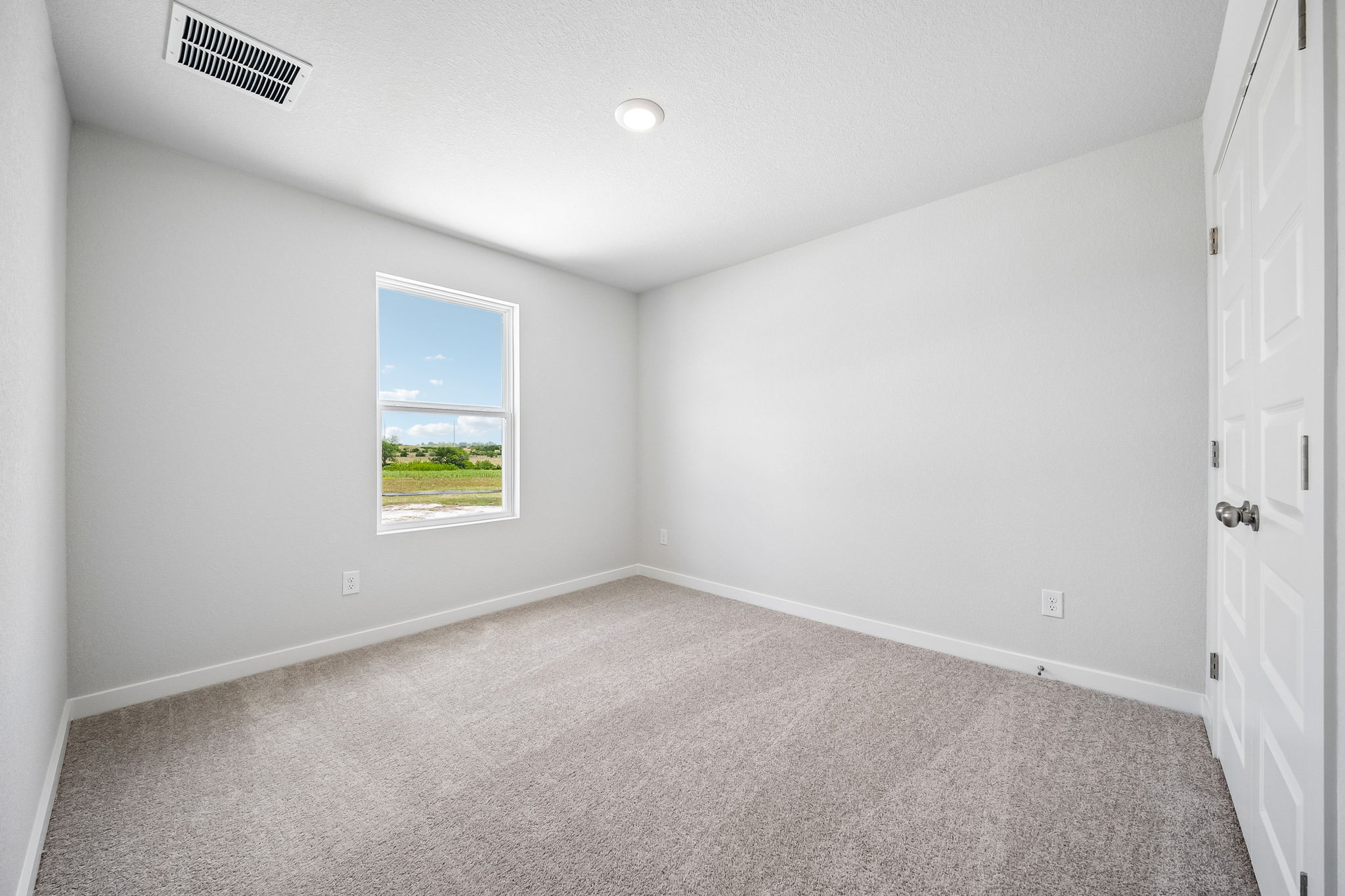 A room with a window and a carpet.