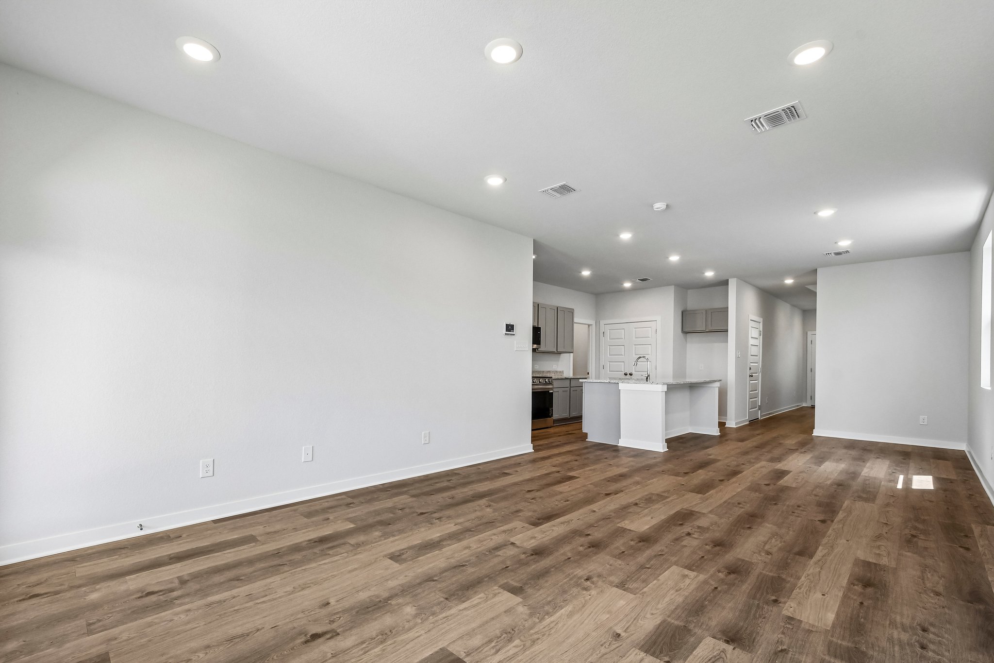 A large empty room with white cabinets.