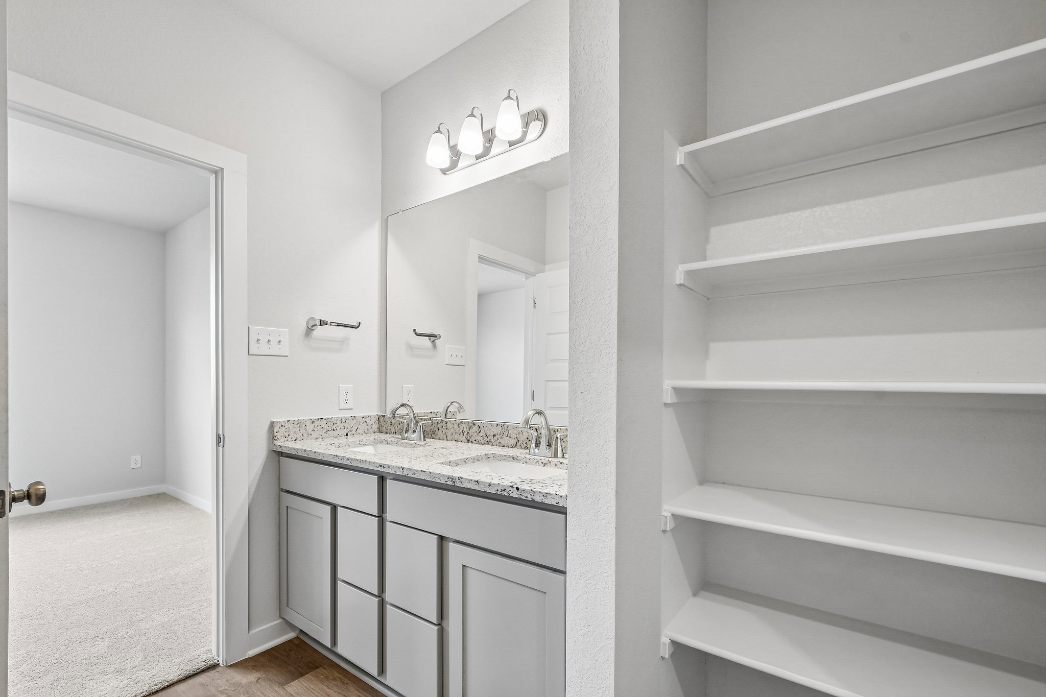 A bathroom with white cabinets.