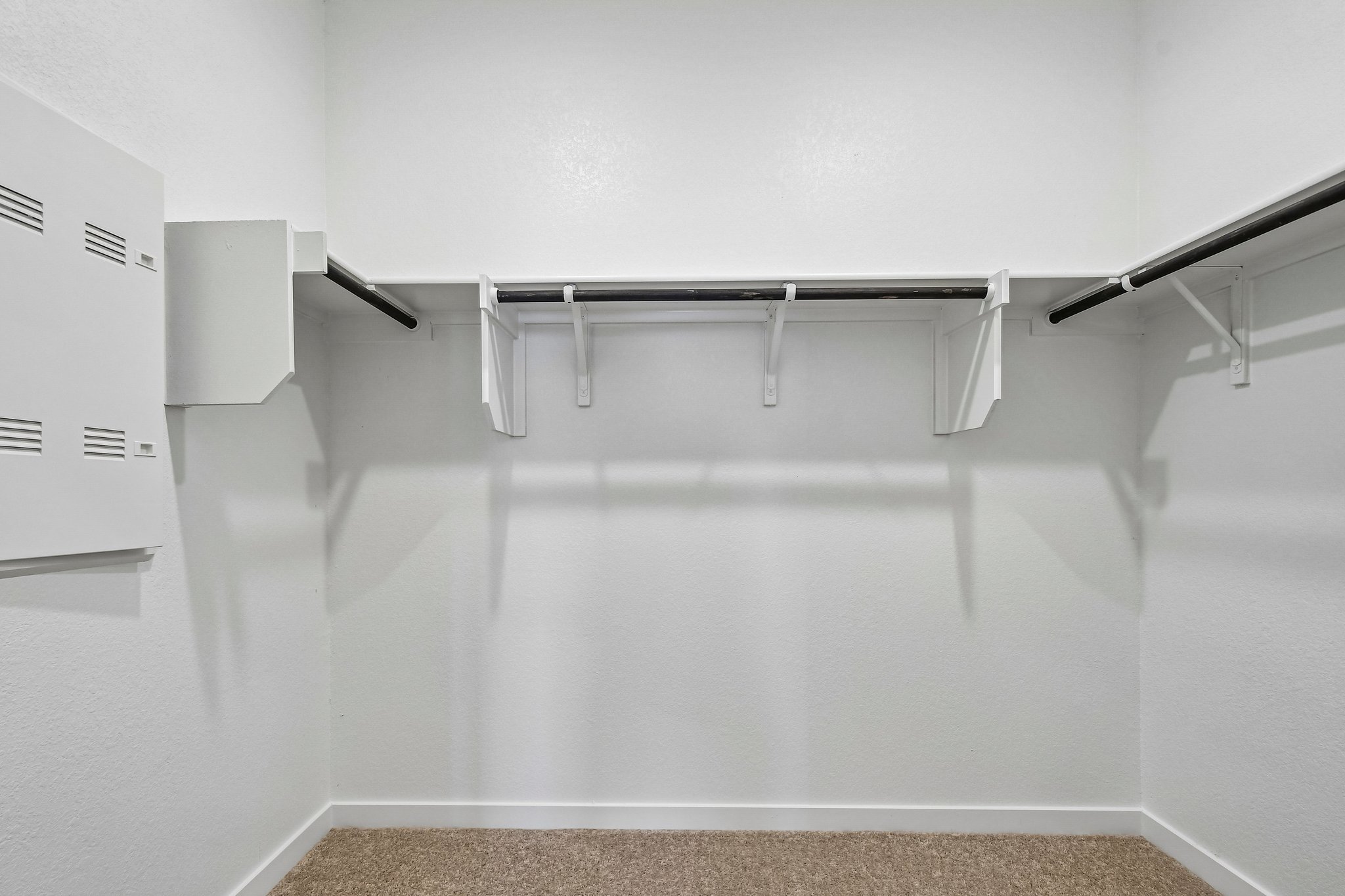 A white wall with a metal bar.