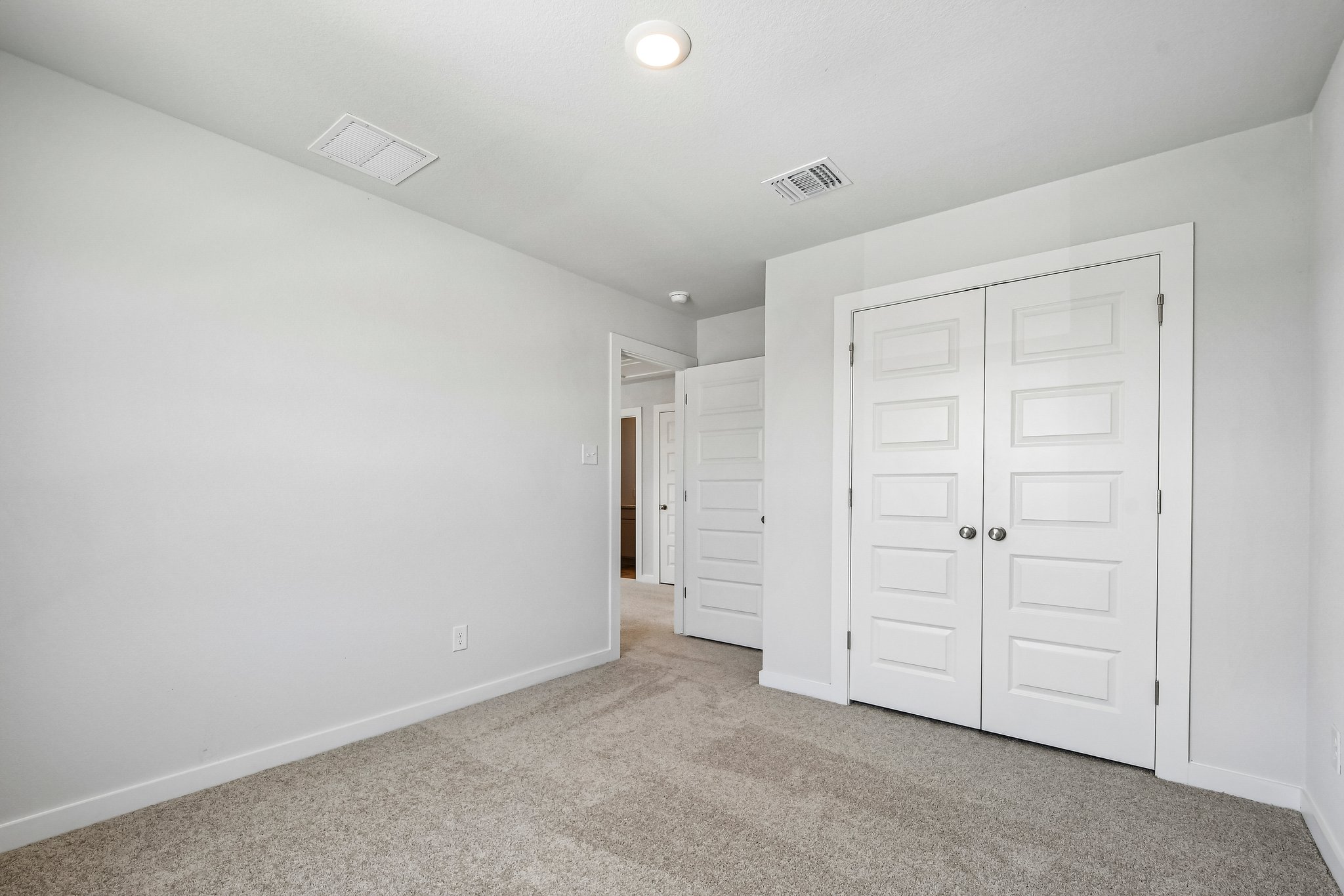 A hallway with white doors.