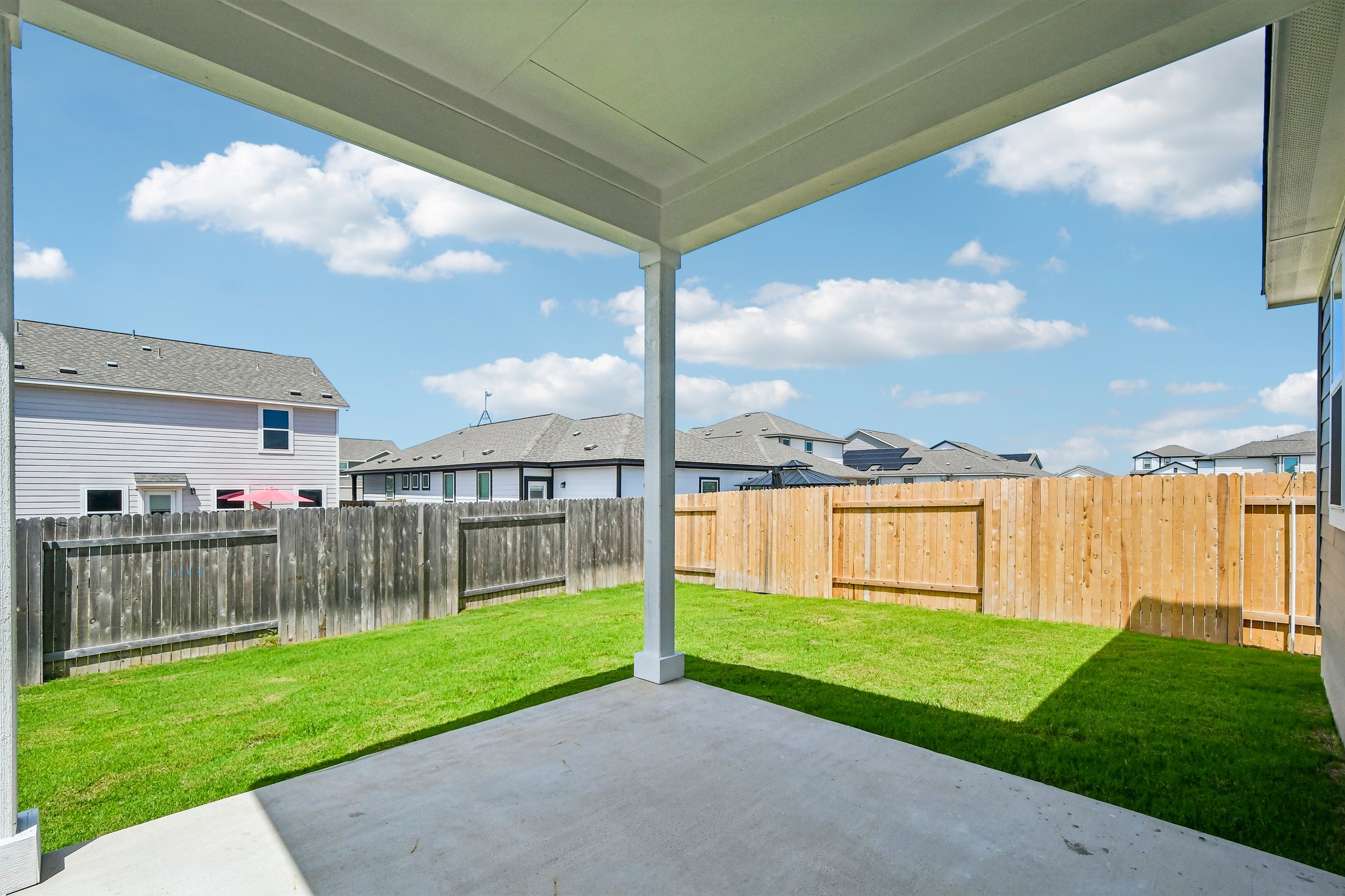 A fenced in yard with a house in the background.