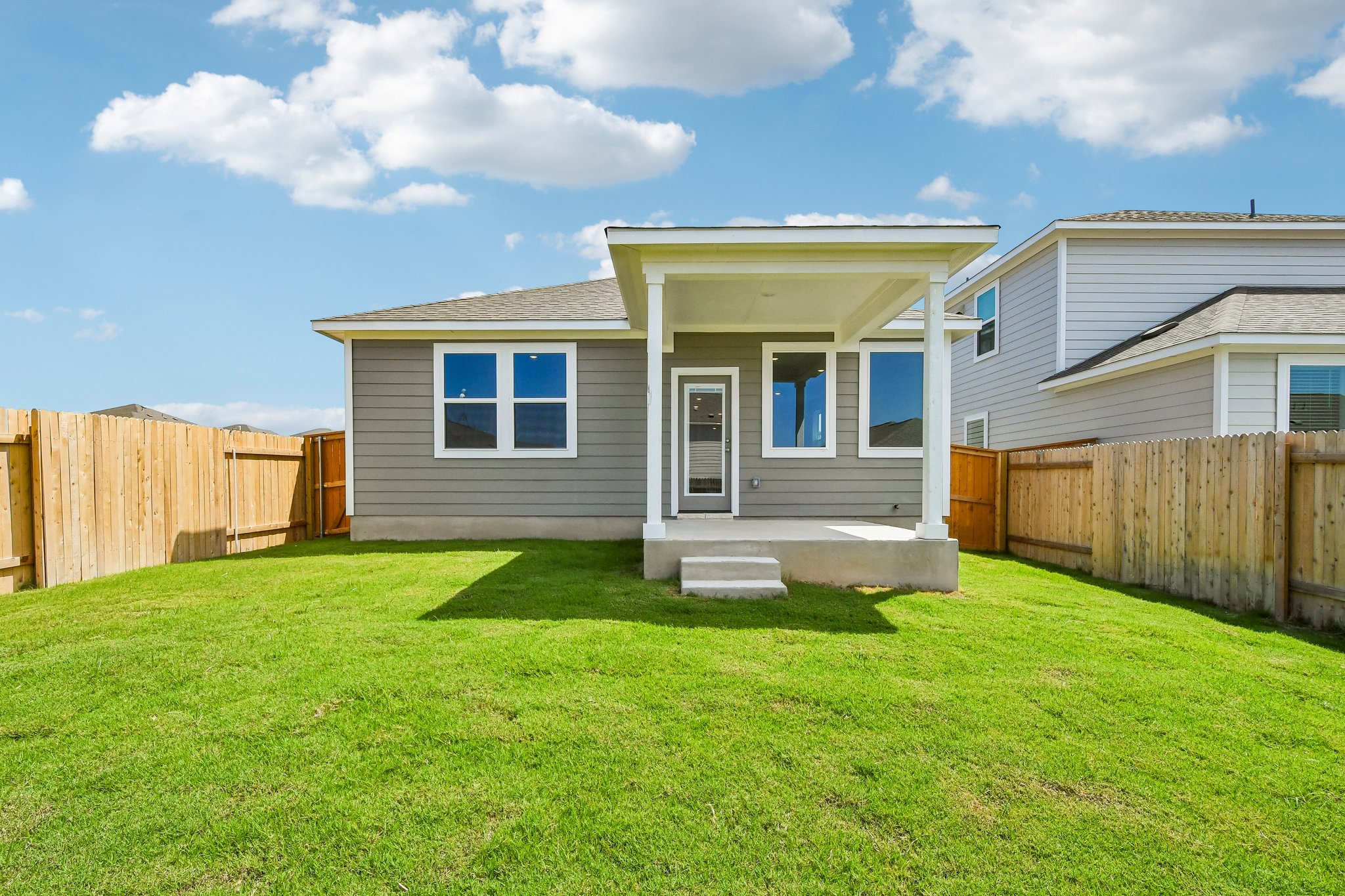 A house with a fence and grass.