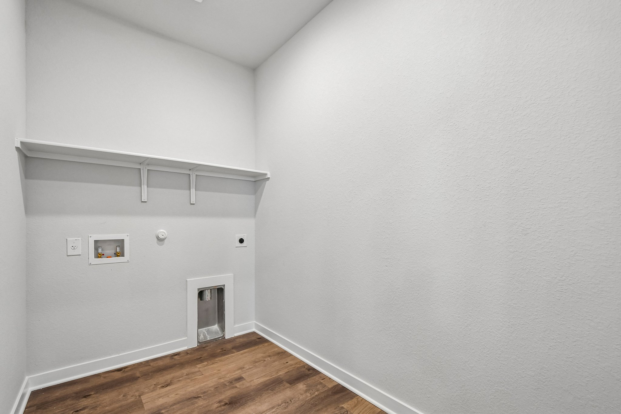 A white room with a wood floor.