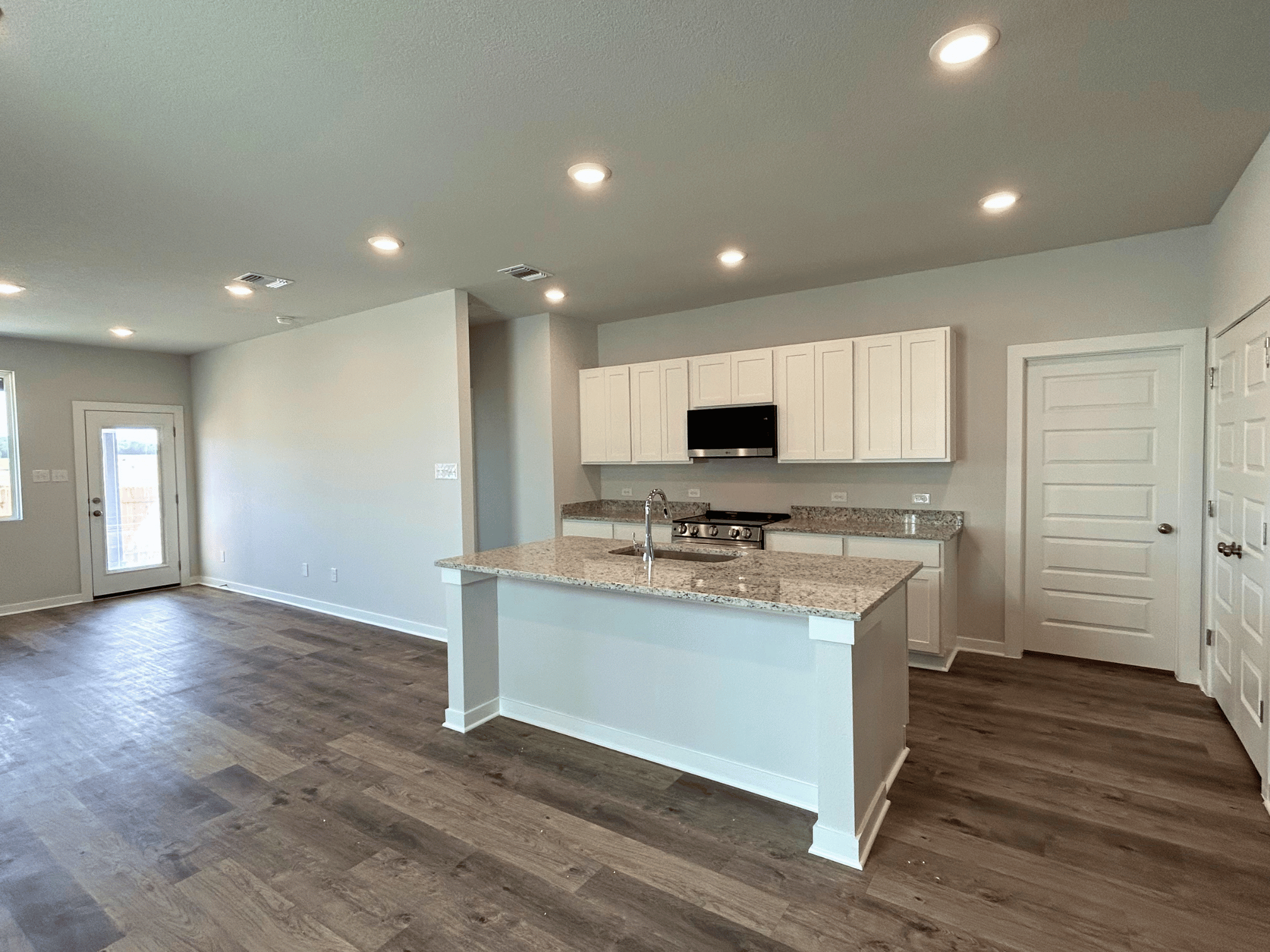 A kitchen with white cabinets.