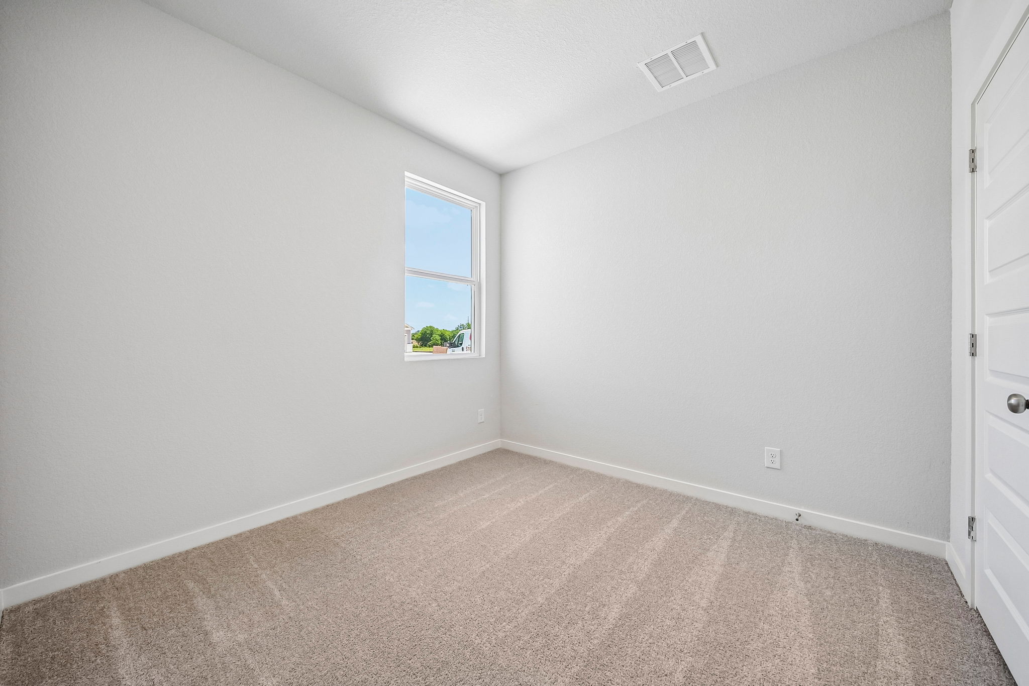 A room with a window and a carpet.