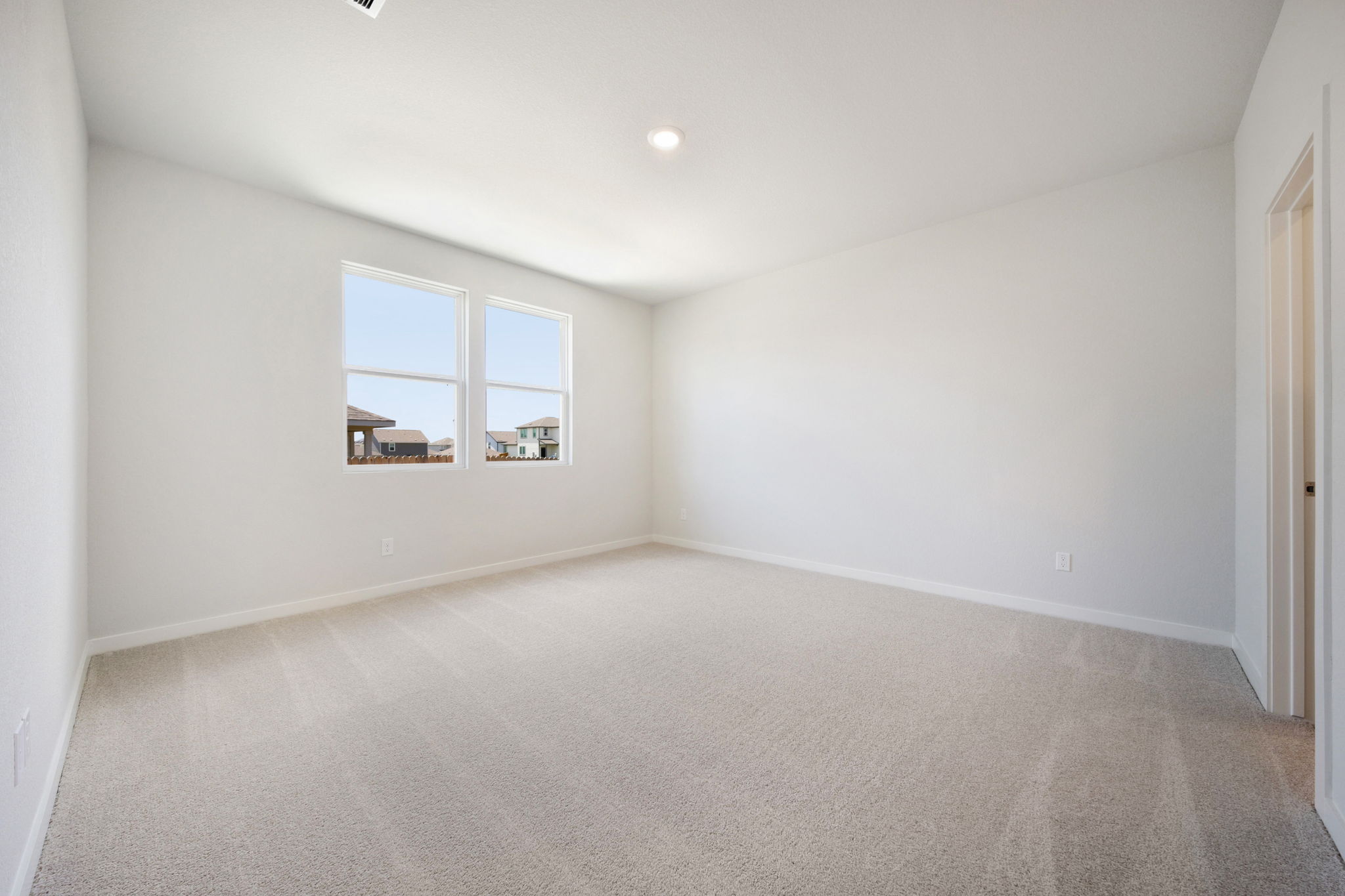 A room with a carpet and windows.