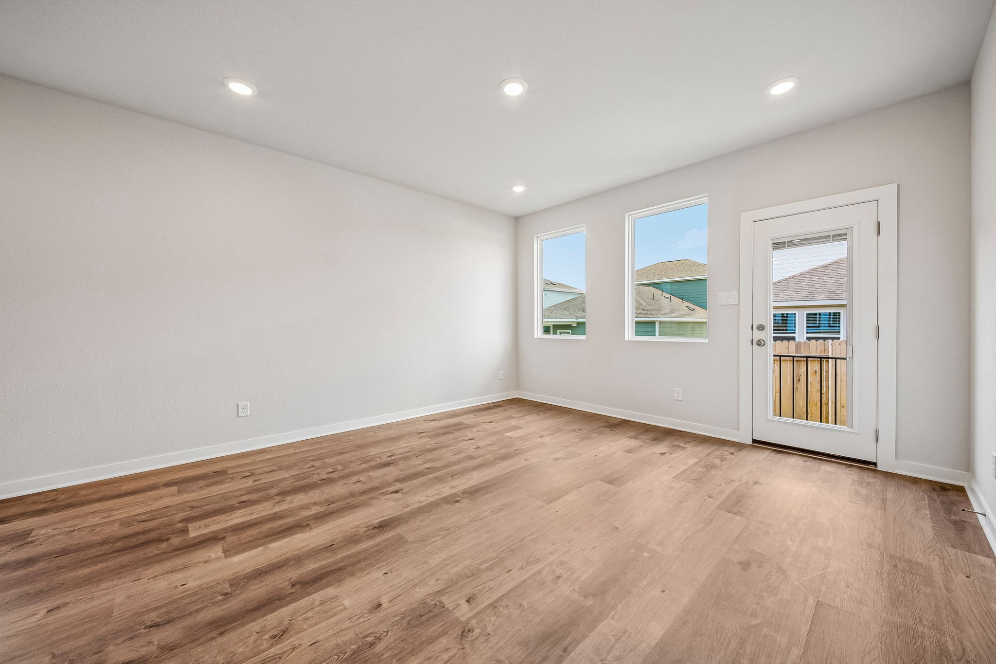 A room with a wood floor and a wood floor with a white door.