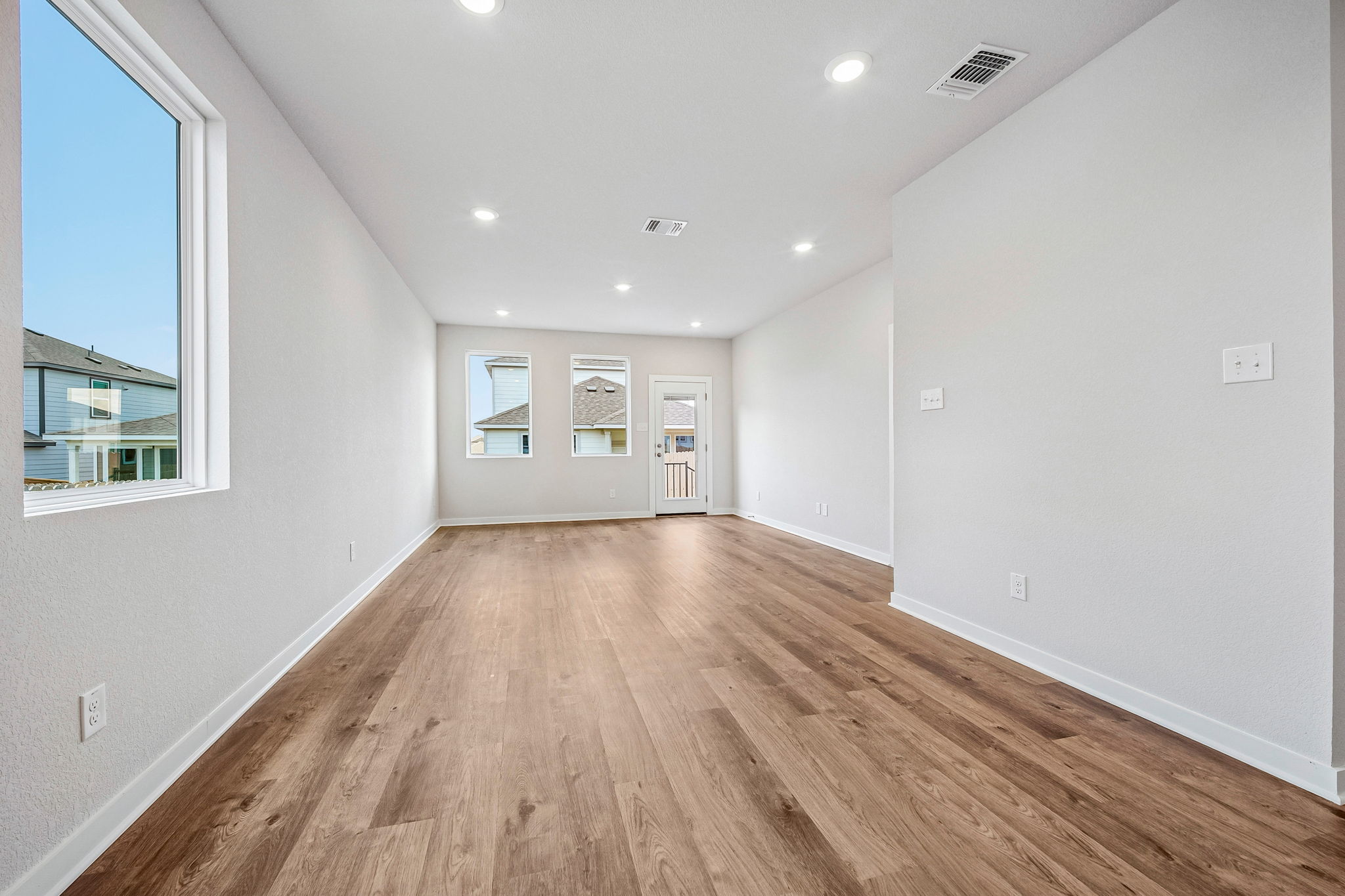 A room with a wood floor and a window.