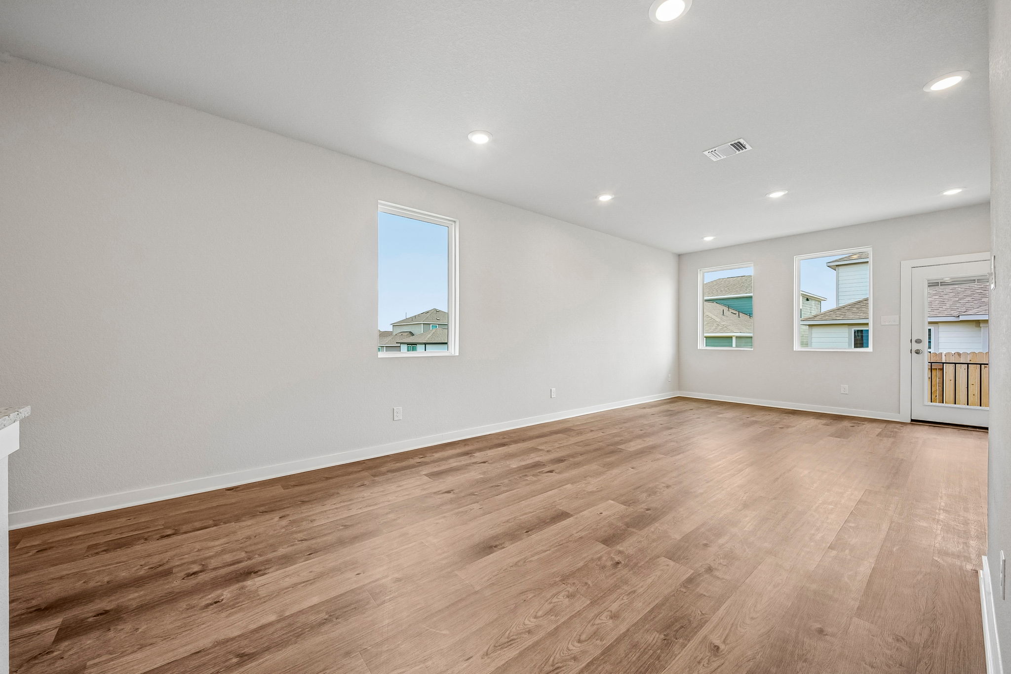 A room with a wood floor and a wood floor with pictures on the wall.