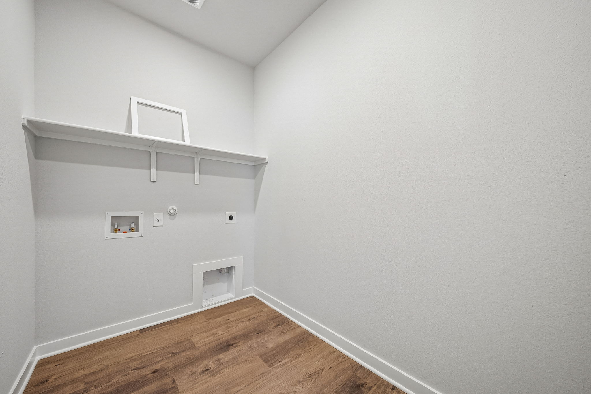 A white room with a wood floor.