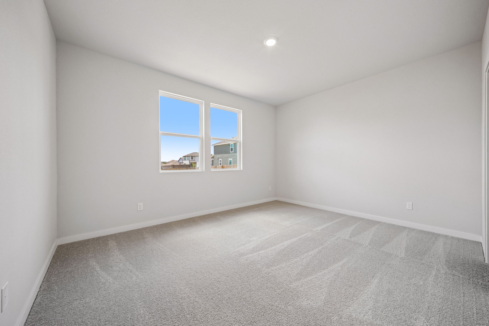 A room with a window and a carpet.