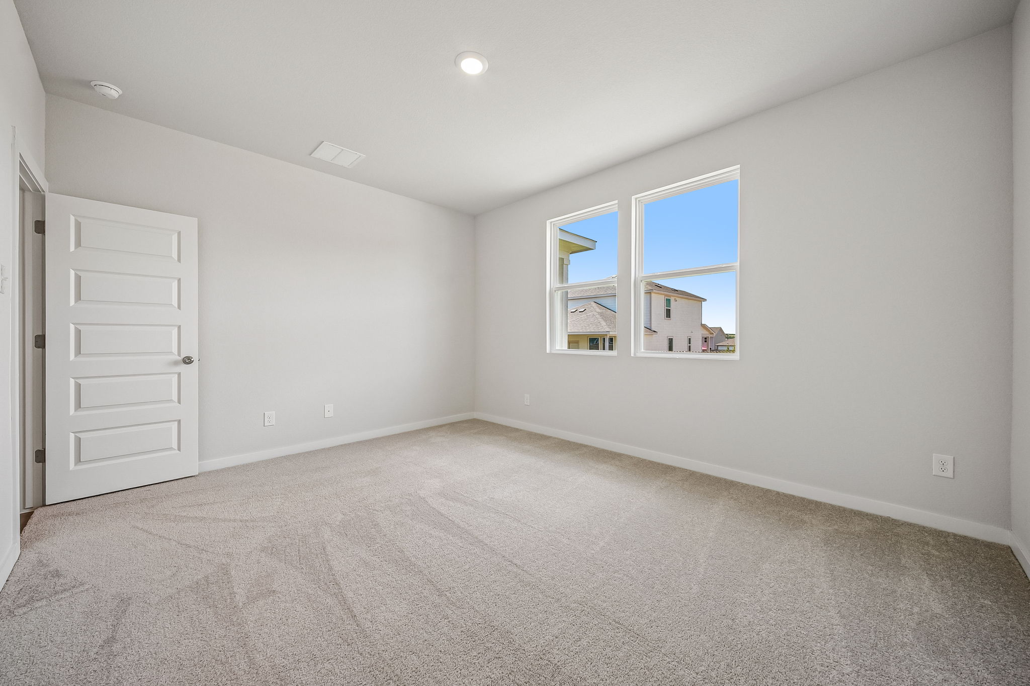 A room with a window and a white door.