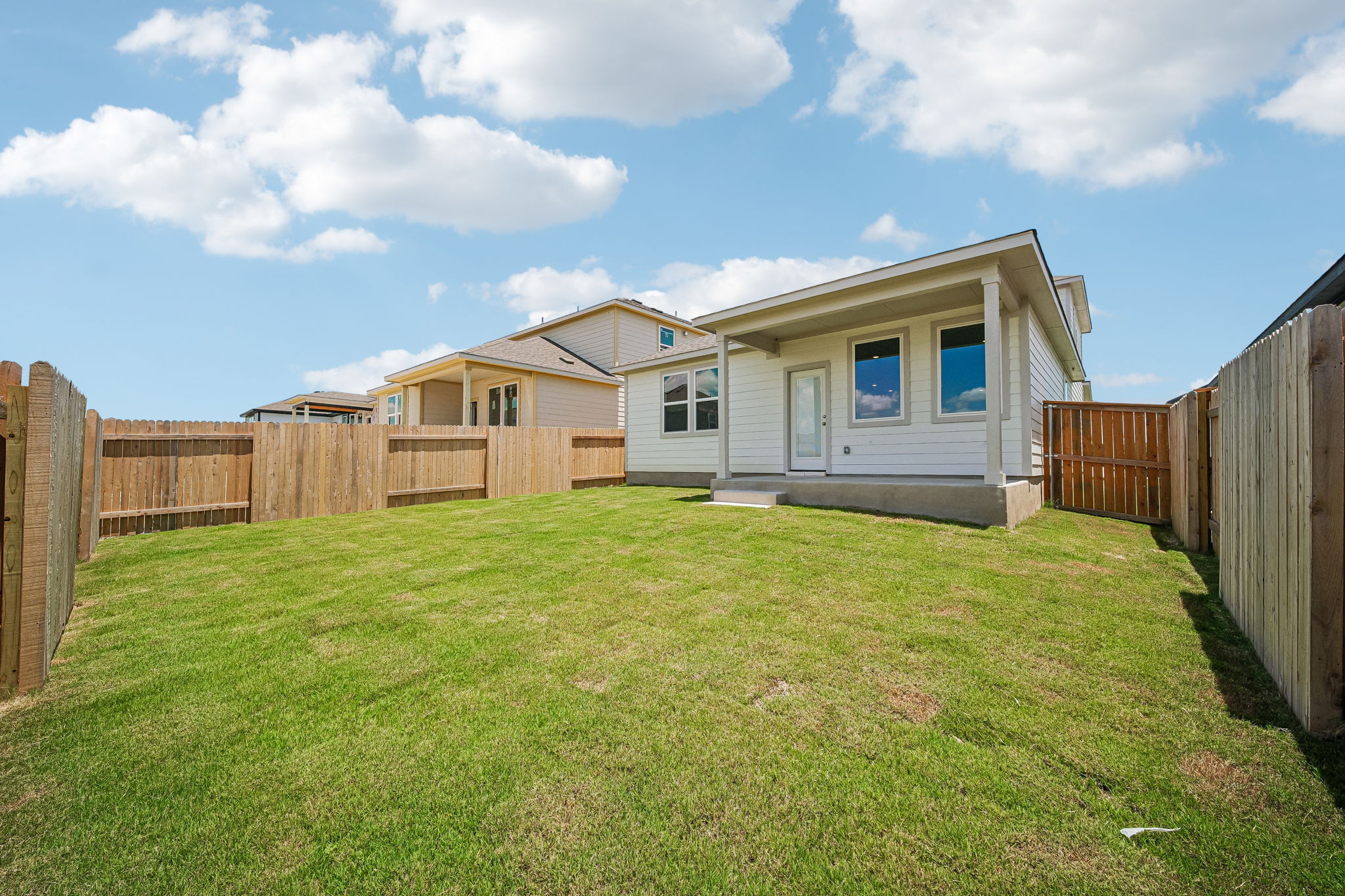 A fenced in yard with a house and a fence.