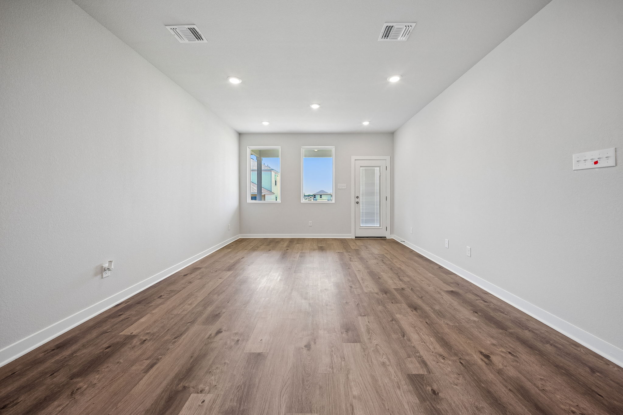 A room with white walls and a wood floor.