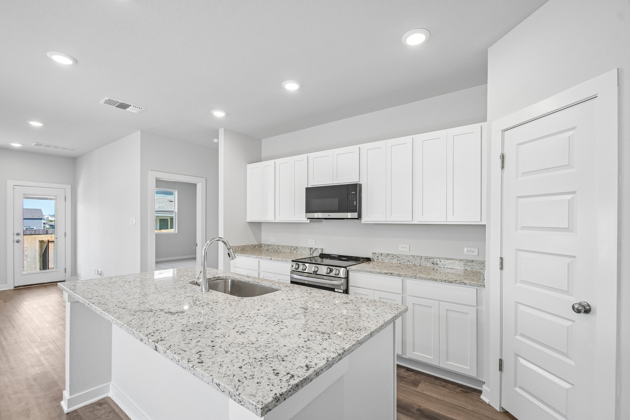 A kitchen with white cabinets.