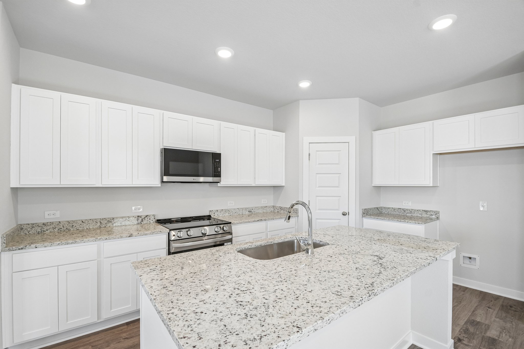 A kitchen with white cabinets.